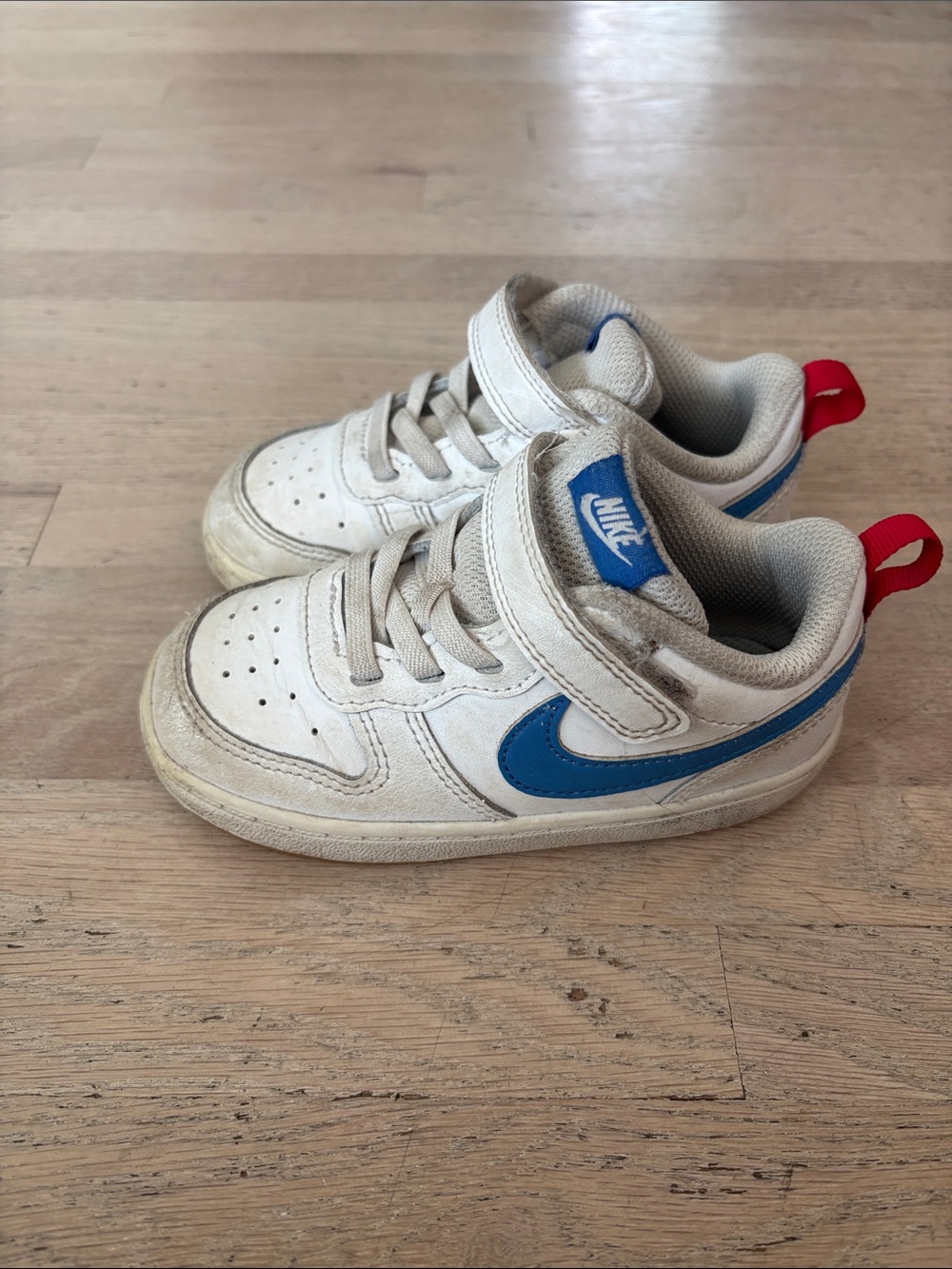 Nike Kids White Sneakers with Blue Swoosh and Red Heel Tab
